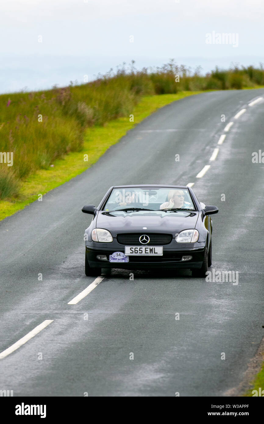 Années 1998 90 ninetiesblack Mercedes SLK 230 Kompressor Auto à Scorton, Lancashire. Le Lancashire car Club Rally Coast to Coast traverse le creux de Bowland. 74 véhicules vintage, classiques, à collectionner, patrimoniaux et historiques ont quitté Morecambe pour un voyage à travers le comté au-dessus du paysage du Lancashire jusqu'à Whitby. Une randonnée de 170 kilomètres sur un paysage vallonné dans le cadre de l'événement annuel du club de voitures classiques sur circuit. Banque D'Images