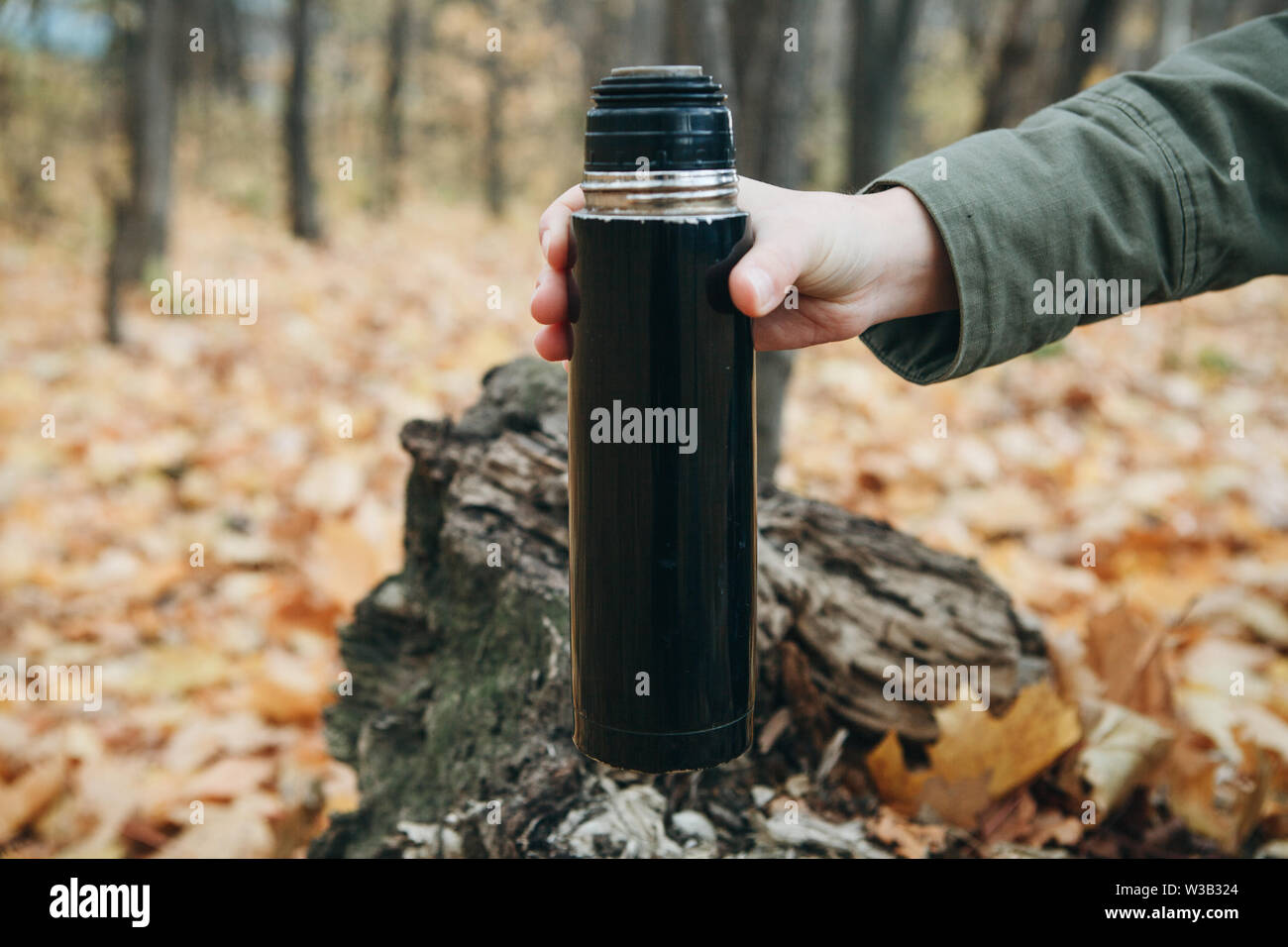 Personne avec un thermos dans ses mains dans la forêt d'automne. L'homme  doit boire boire goyang - thé ou café pour garder au chaud Photo Stock -  Alamy