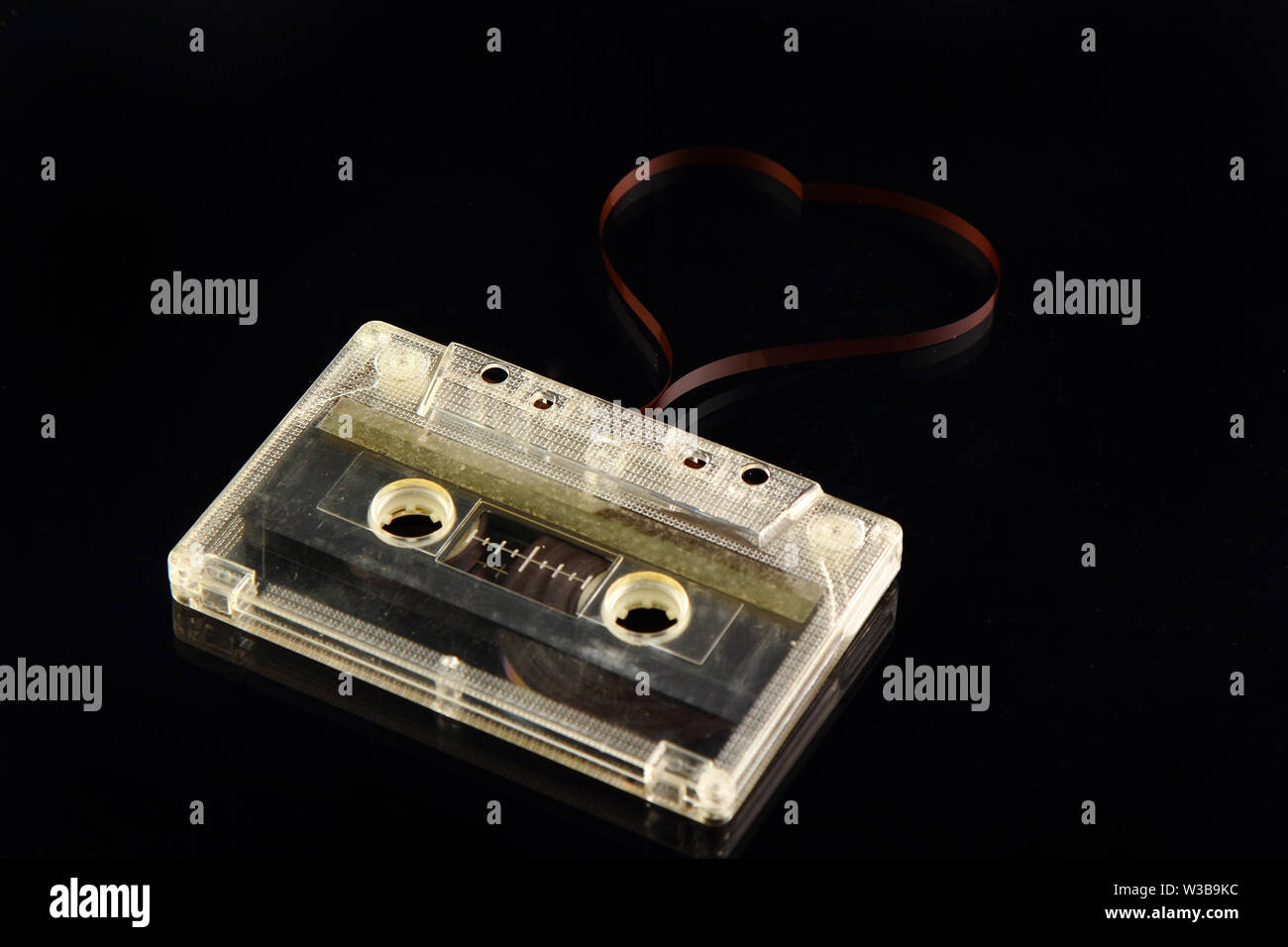 Cassette audio sur fond noir. L'élaboration du film coeur carte postale de la Saint-Valentin. Texte de l'étiquette de chansons d'amour. Banque D'Images
