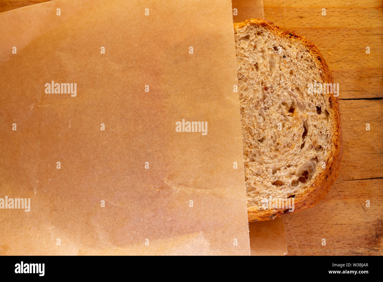 Regardant vers le bas sur une tomate et fromage sandwich sur granary poussant hors d'un sac en papier brun sur le dessus d'une vieille planche, avec espace pour copier Banque D'Images