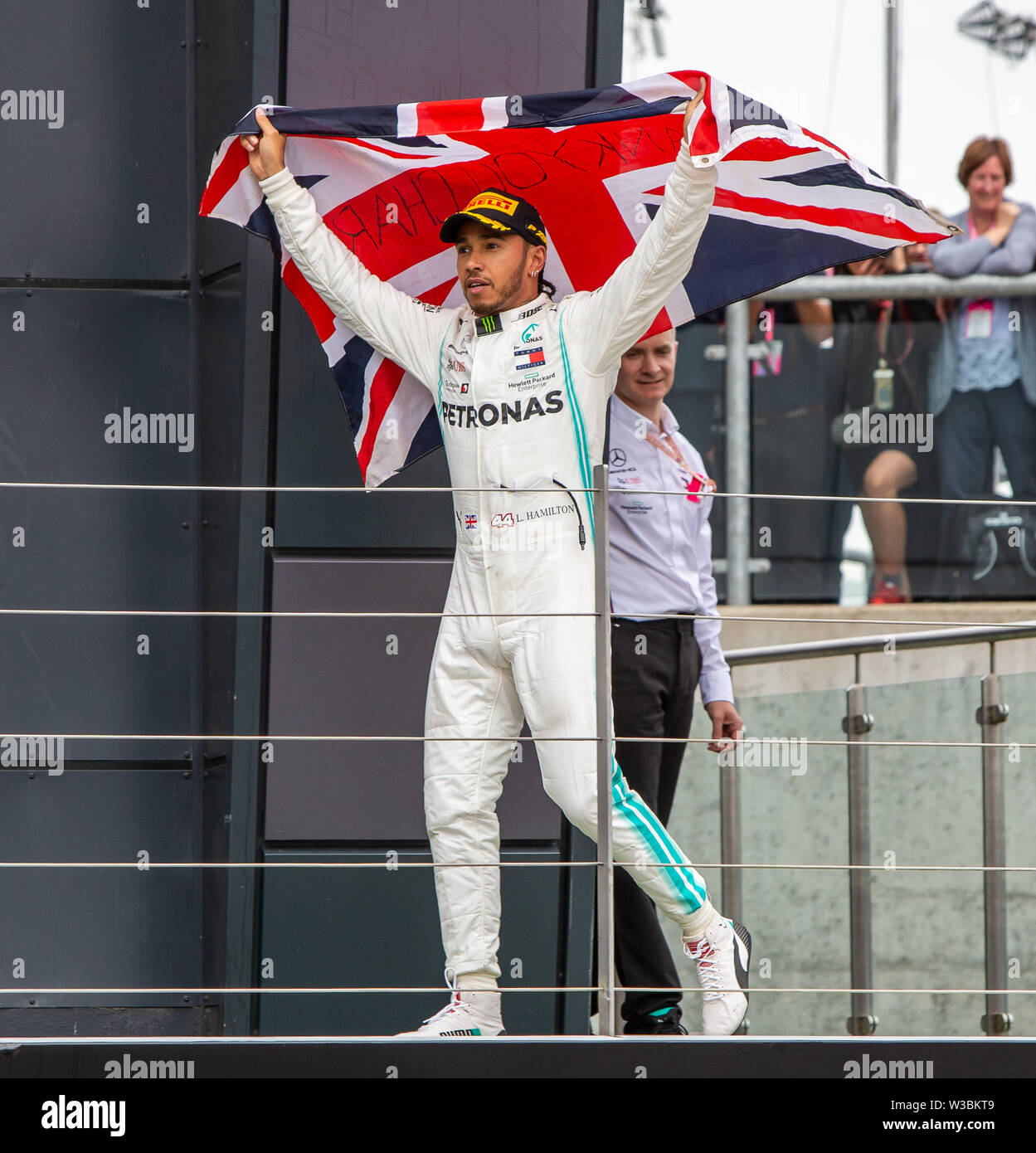 Silverstone, UK. 14 juillet 2019. FIA F1 Grand Prix de Grande-Bretagne, la  Journée de la course ; Mercedes AMG Petronas Motorsport Lewis Hamilton  pilote brandit une Union Jack flag pendant qu'il marche