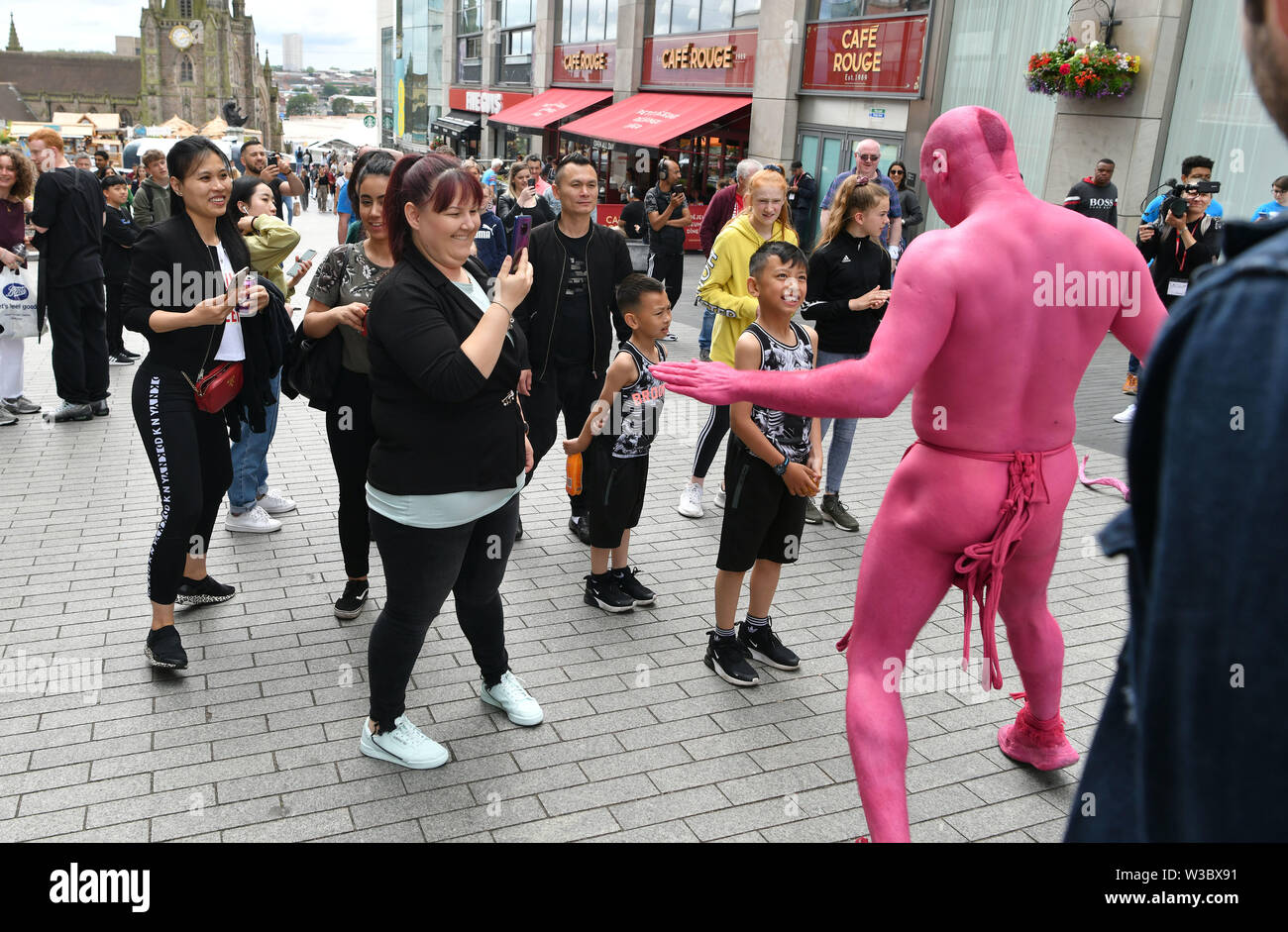 Les artistes de rue se mélangent avec les membres du public dans la région des arènes de Birmingham. Les spectacles faisaient partie de l'été annuel au Southside Arts Festival. Banque D'Images