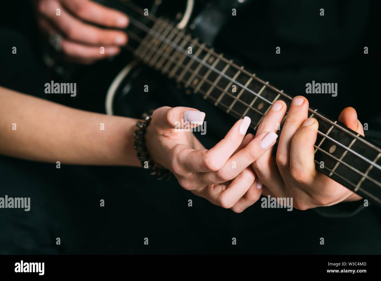 Nous aimons la musique. Couple in love jouer en duo. Les mains des hommes  et des femmes jouer de la guitare électrique. Couple de joueurs de guitare.  Couple de musiciens aiment jouer