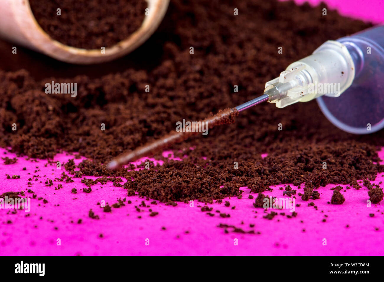 La poudre de café sur fond rose avec seringue de caféine pure Banque D'Images