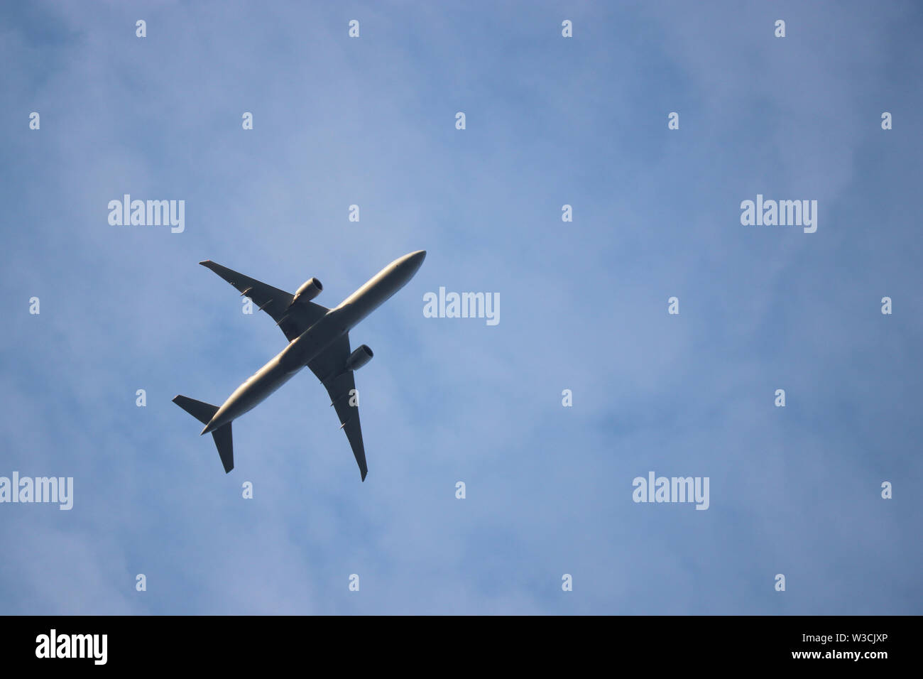 Vol d'un avion dans le ciel bleu, les voyages aériens. Silhouette de bimoteur commercial avion au décollage sur fond de nuages blancs, concept de turbulence Banque D'Images