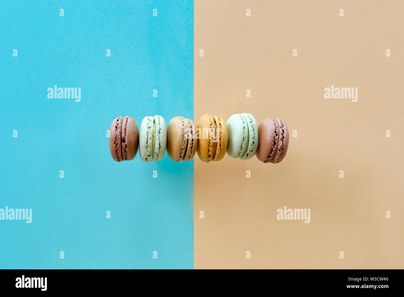 Rangée de weet et savoureux macarons, télévision jeter sur papier fond split Banque D'Images