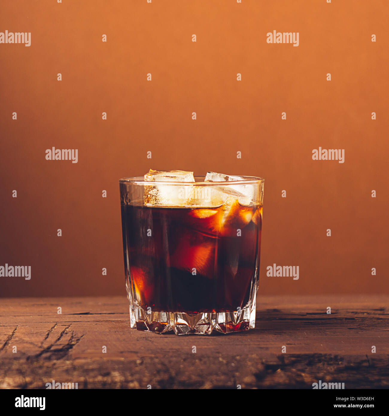 Un verre de boisson alcoolisée forte whiskey brandy sur un fond de bois sombre. Focus sélectif. Cadre carré Banque D'Images