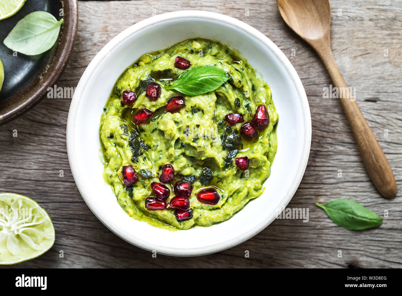 Trempette à l'avocat l'huile d'olive au basilic et de grenadier topping Banque D'Images