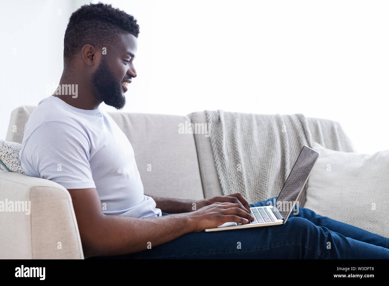 Homme noir millénaire working on laptop in office Banque D'Images