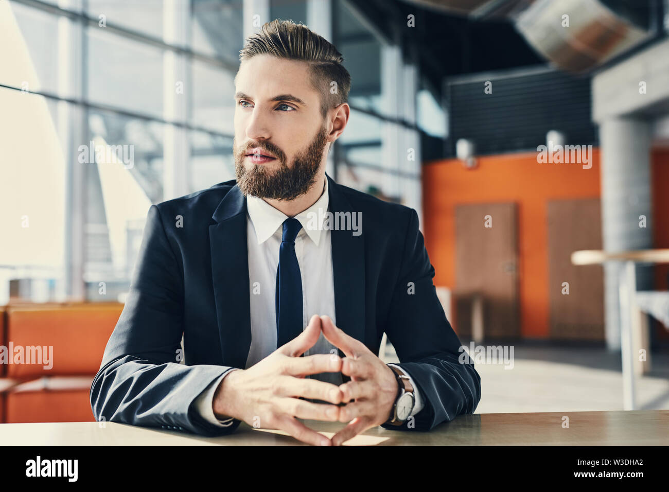 Pensive businessman looking away assis à un bureau moderne Banque D'Images