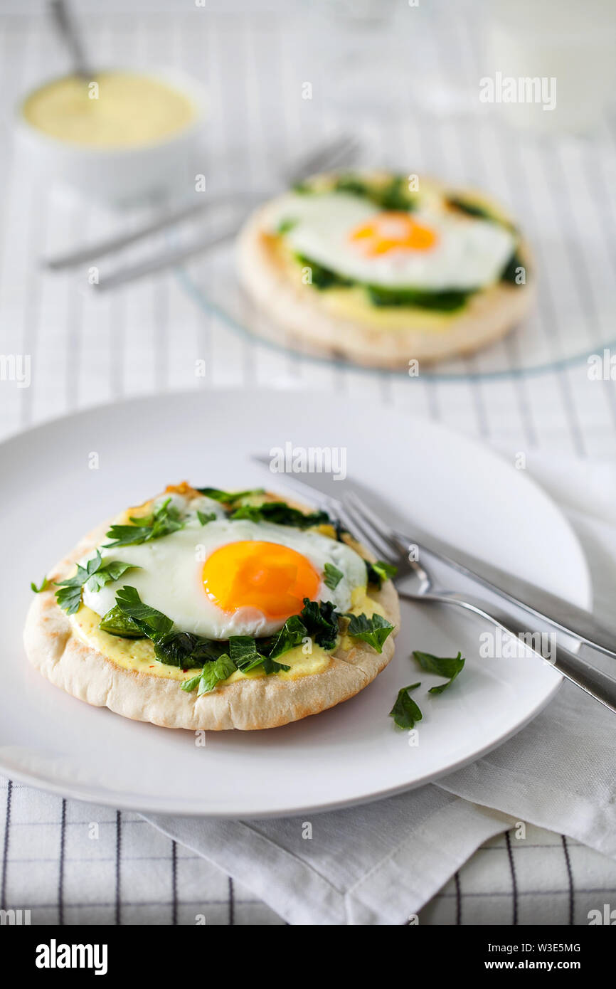 Petit-déjeuner ou un brunch maison saine (repas rapide) à base d'œufs au plat avec des épices indiennes et épinards sautés utilisés en haut de pitas grillés Banque D'Images