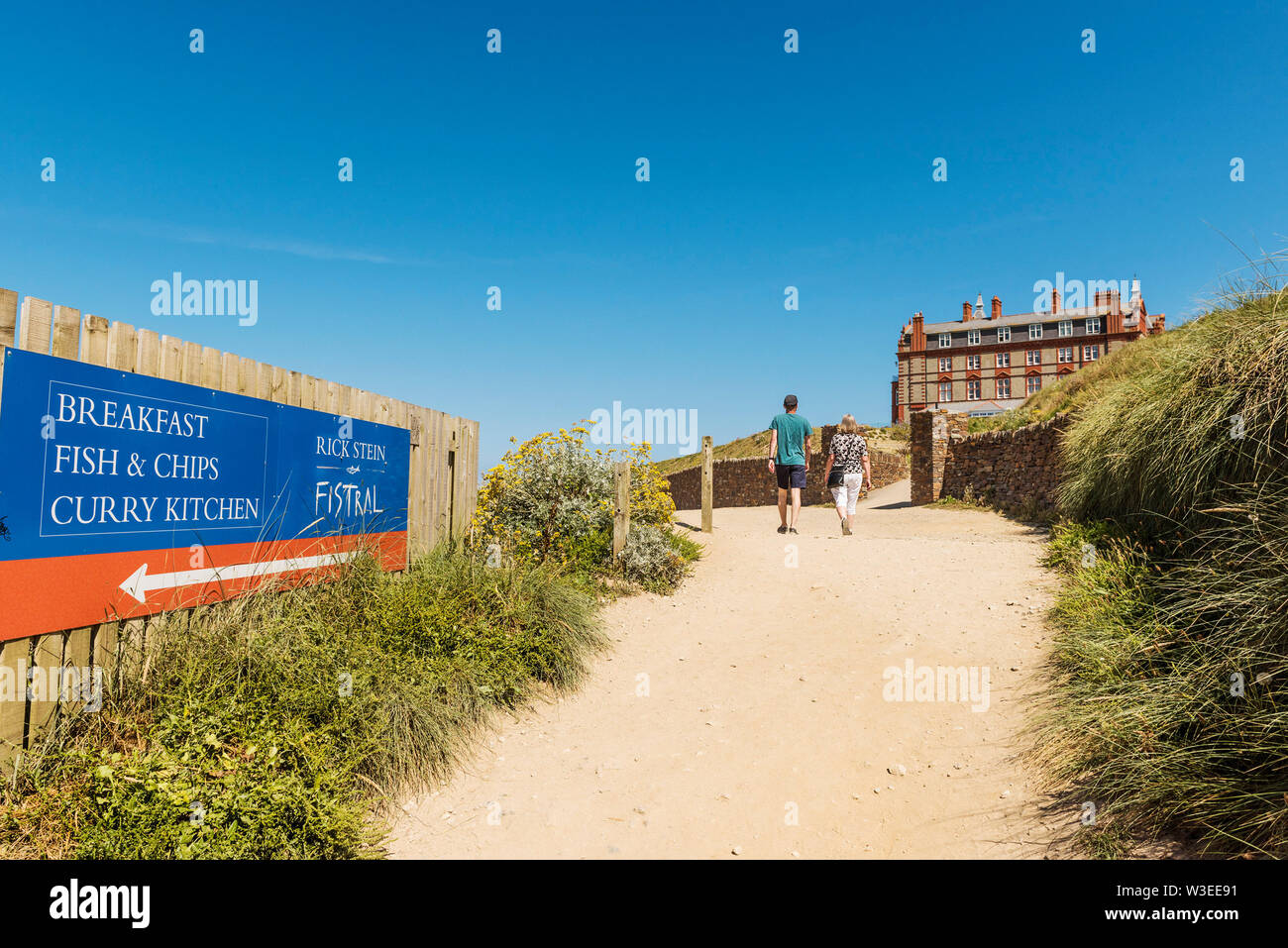 Les vacanciers en marchant le long du sentier du littoral à l'arrière de la pointe à l'hôtel à Newquay Fistral à Cornwall. Banque D'Images