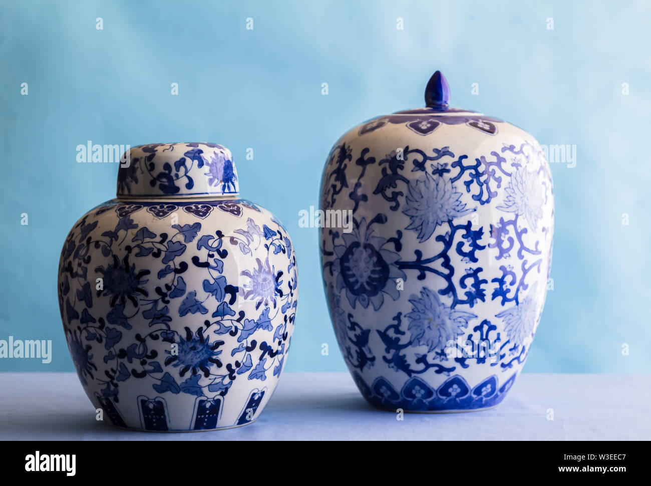 Nature morte avec deux gingembre en céramique bleu et blanc bols isolé sur bleu - vue latérale avec un focus sélectif Banque D'Images