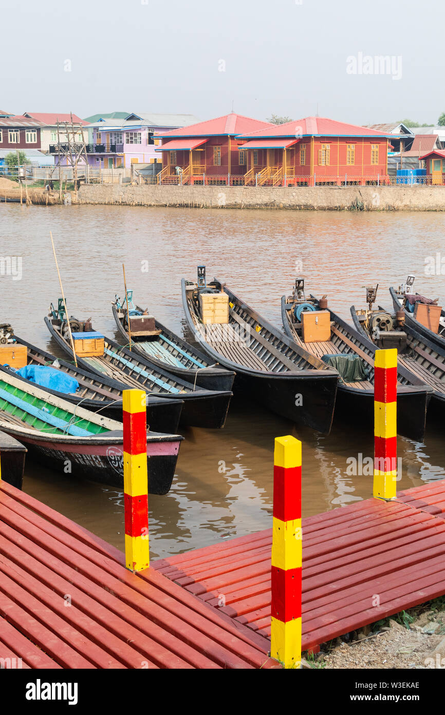 Haspres Thauk, Myanmar - Avril 2019 : Birman traditionnel maison flottante reflétant dans l'eau du lac Inle. Bateaux sur l'avant-plan. Banque D'Images