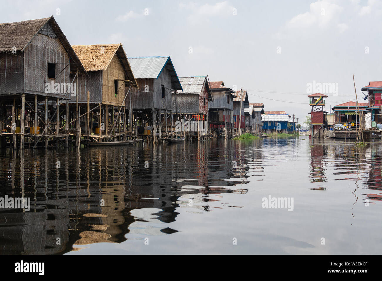 Haspres Thauk, Myanmar - Avril 2019 : Birman traditionnel maison flottante reflétant dans l'eau du lac Inle. Banque D'Images
