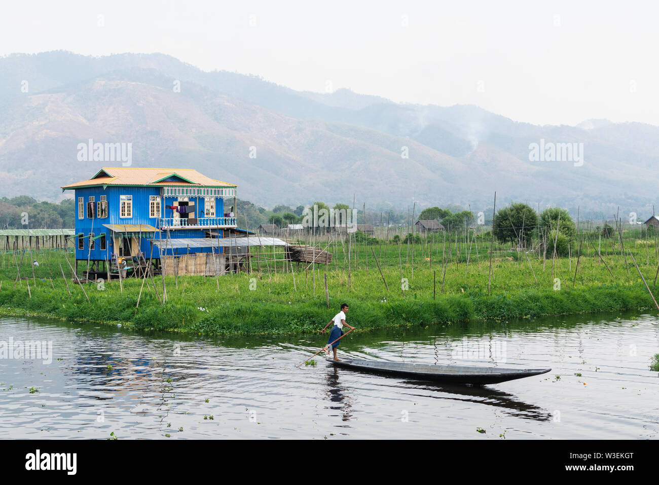 Haspres Thauk, Myanmar - Avril 2019 : Birman traditionnel maison flottante reflétant dans l'eau du lac Inle. Banque D'Images