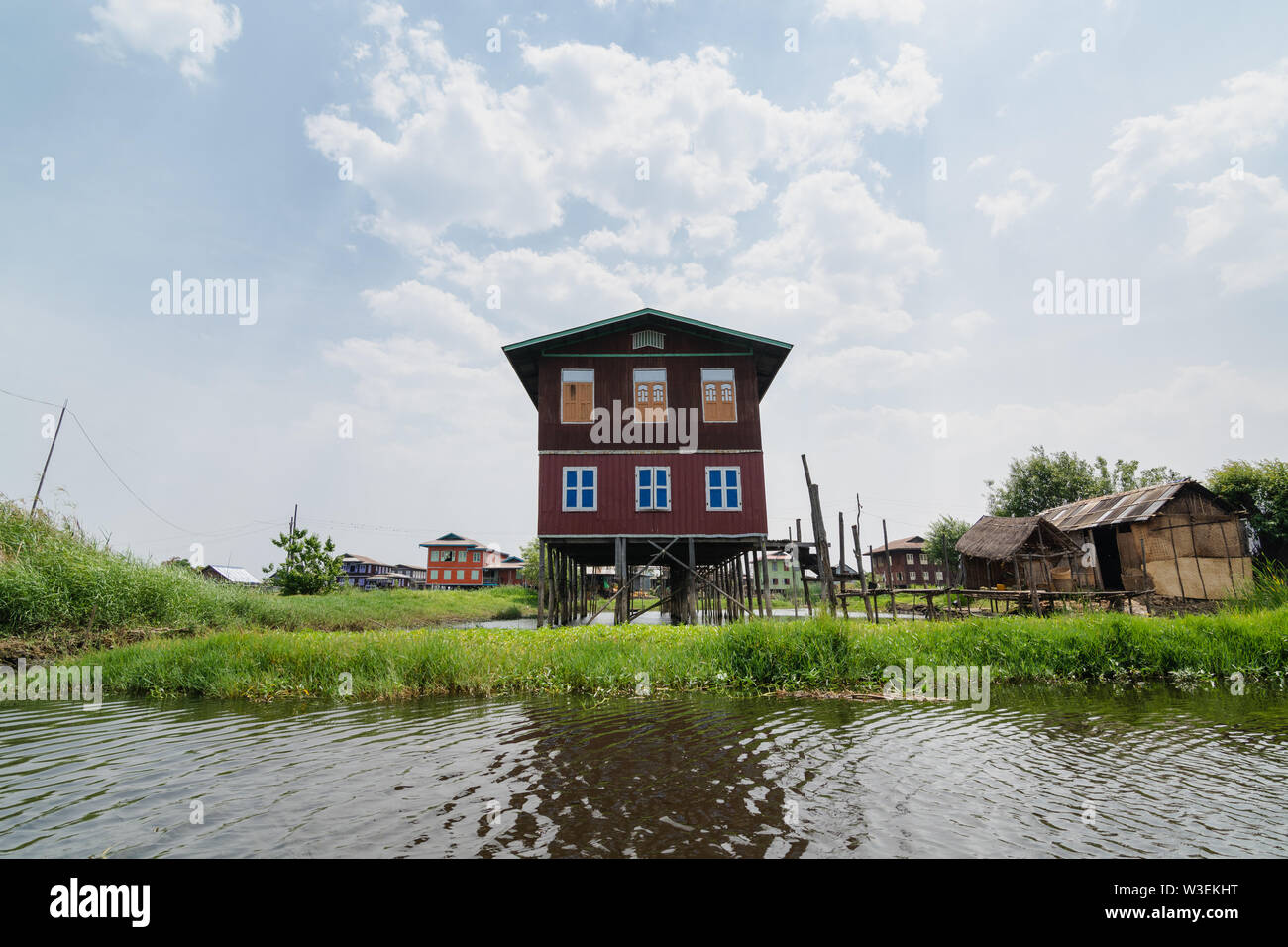 Haspres Thauk, Myanmar - Avril 2019 : Birman traditionnel maison flottante reflétant dans l'eau du lac Inle. Banque D'Images