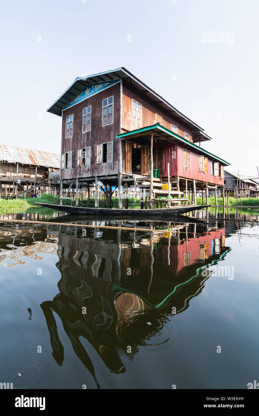 Haspres Thauk, Myanmar - Avril 2019 : Birman traditionnel maison flottante reflétant dans l'eau du lac Inle. Banque D'Images