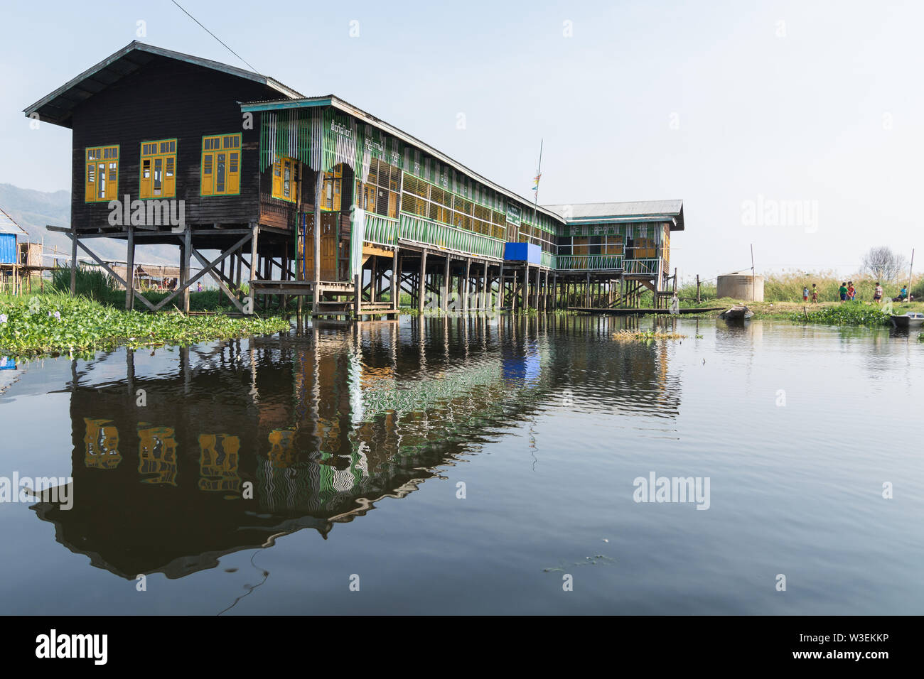 Haspres Thauk, Myanmar - Avril 2019 : école flottante birman traditionnel reflétant dans l'eau du lac Inle. Banque D'Images