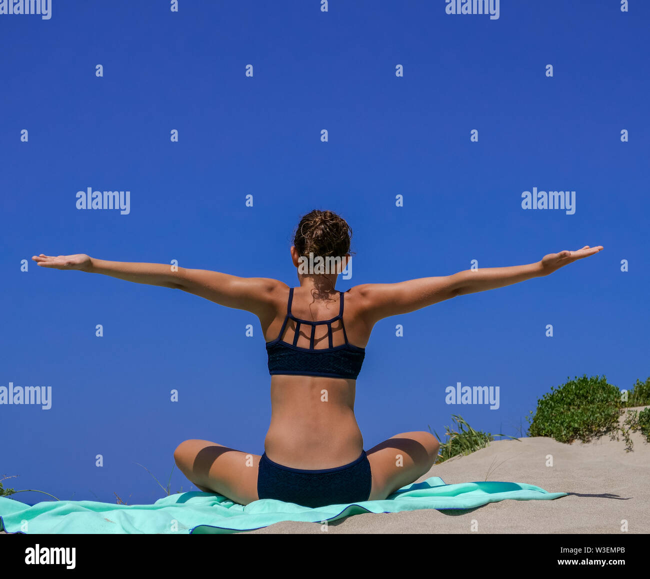 Et Slim athletic girl dans un bikini noir pratiquant le yoga posent devant un magnifique ciel bleu sur une plage de sable. Adapté pour le bien-être, Fitness, Yoga, Spor Banque D'Images