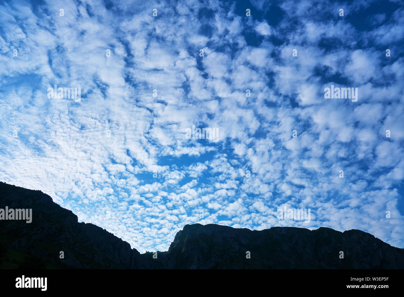 Les nuages Altocumulus floccus, bleu ciel du matin, et une crête de montagne d'ossature. Emplacement : Trascău montagne (partie de Carpates), près de village Rimetea Banque D'Images