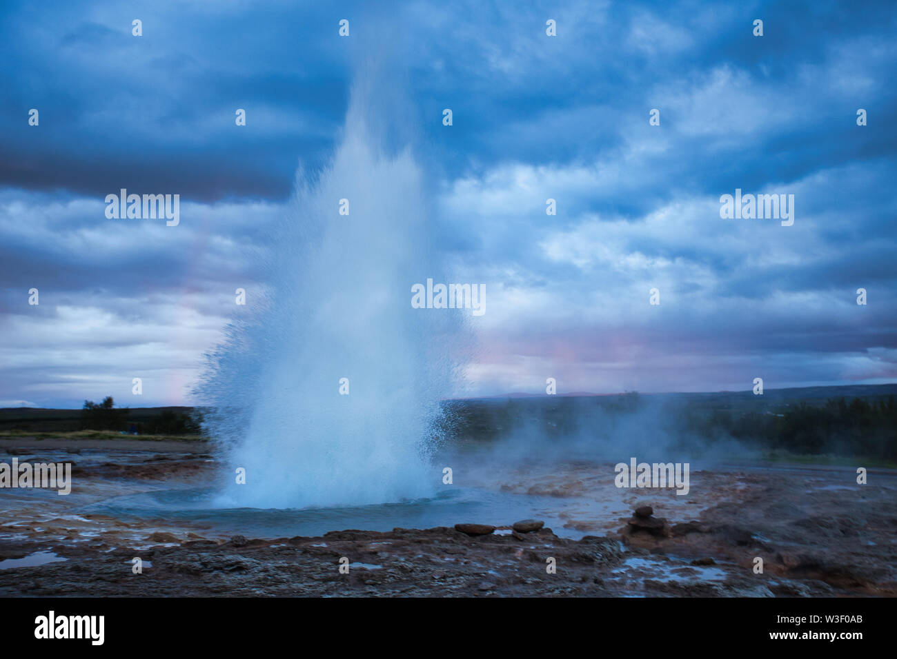 Strokkur Geysir éruption avec ciel nuageux, l'Islande Banque D'Images