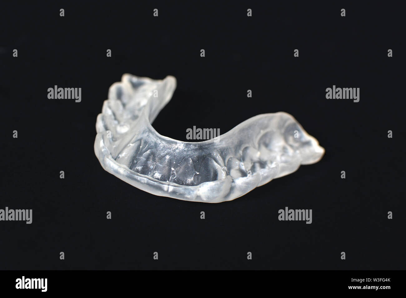 Morsure de dents transparent personnalisé claire garde aligners pour mâchoire inférieure sombre sur fond noir Banque D'Images