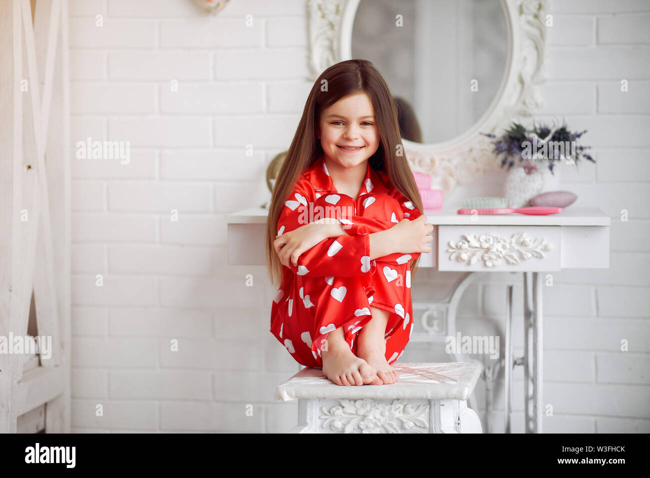 Cute little girl at home dans un pyjama. Banque D'Images