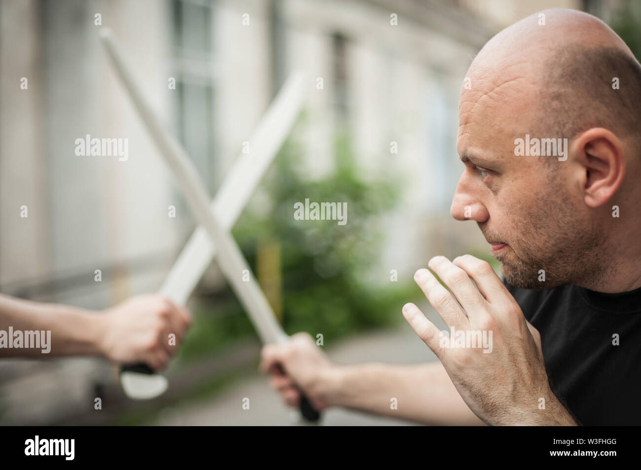 L'Eskrima et wushu démontre l'instructeur technique de combat à la machette avec son élève. Long Couteau arme de la formation. Démonstration avec l'épée en plastique Banque D'Images