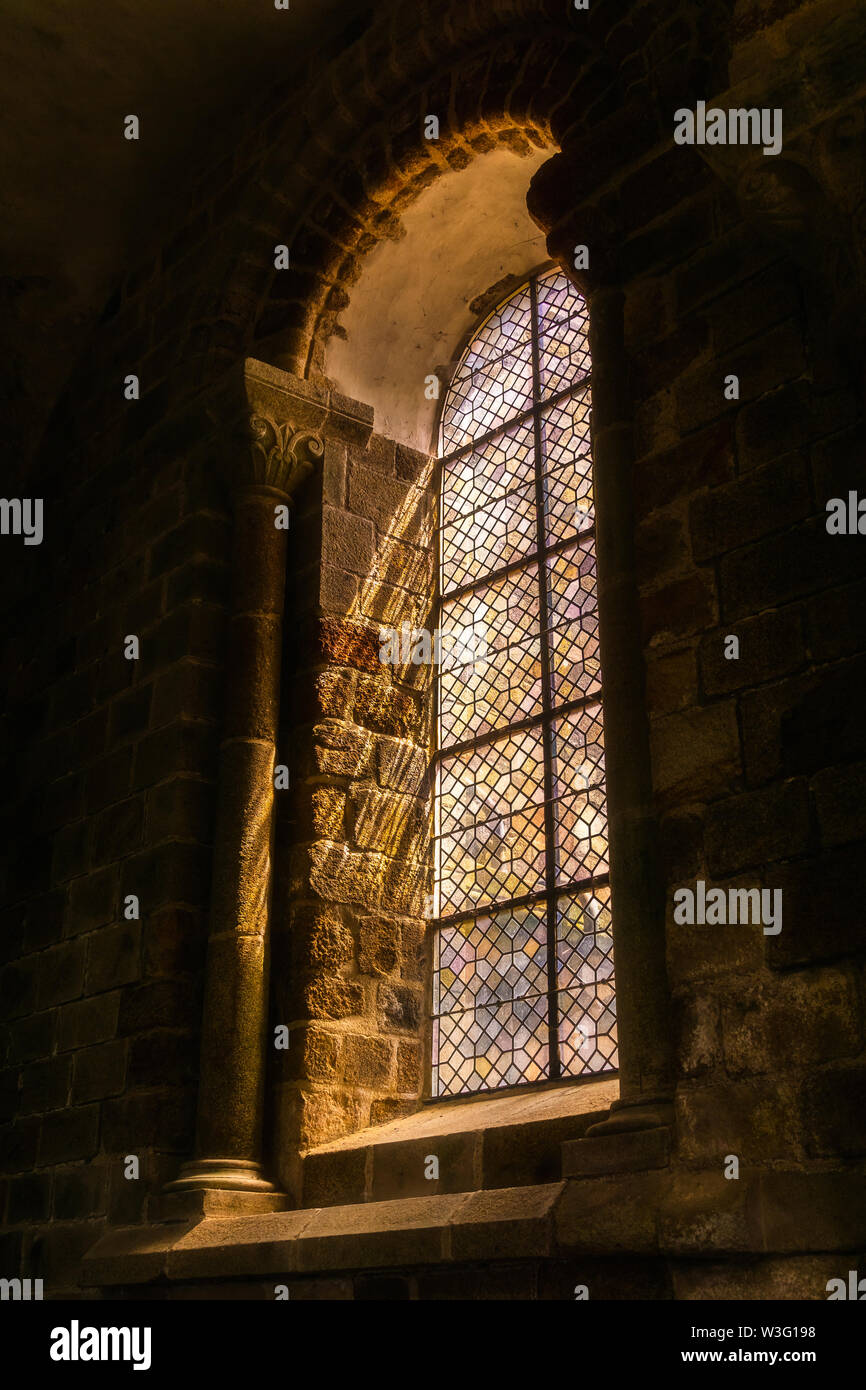 Vitrail dans l'église abbaye du Mont St Michel, l'architecture en pierre romain, Normandie, France. Banque D'Images