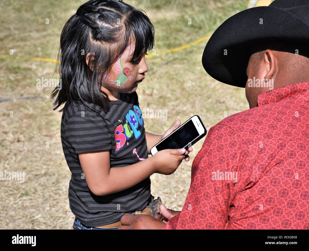 Père hispaniques de parler à ma fille de 5 ans à propos de l'utilisation de son vrai téléphone cellulaire en public et d'être du vrai fort et troublant Banque D'Images