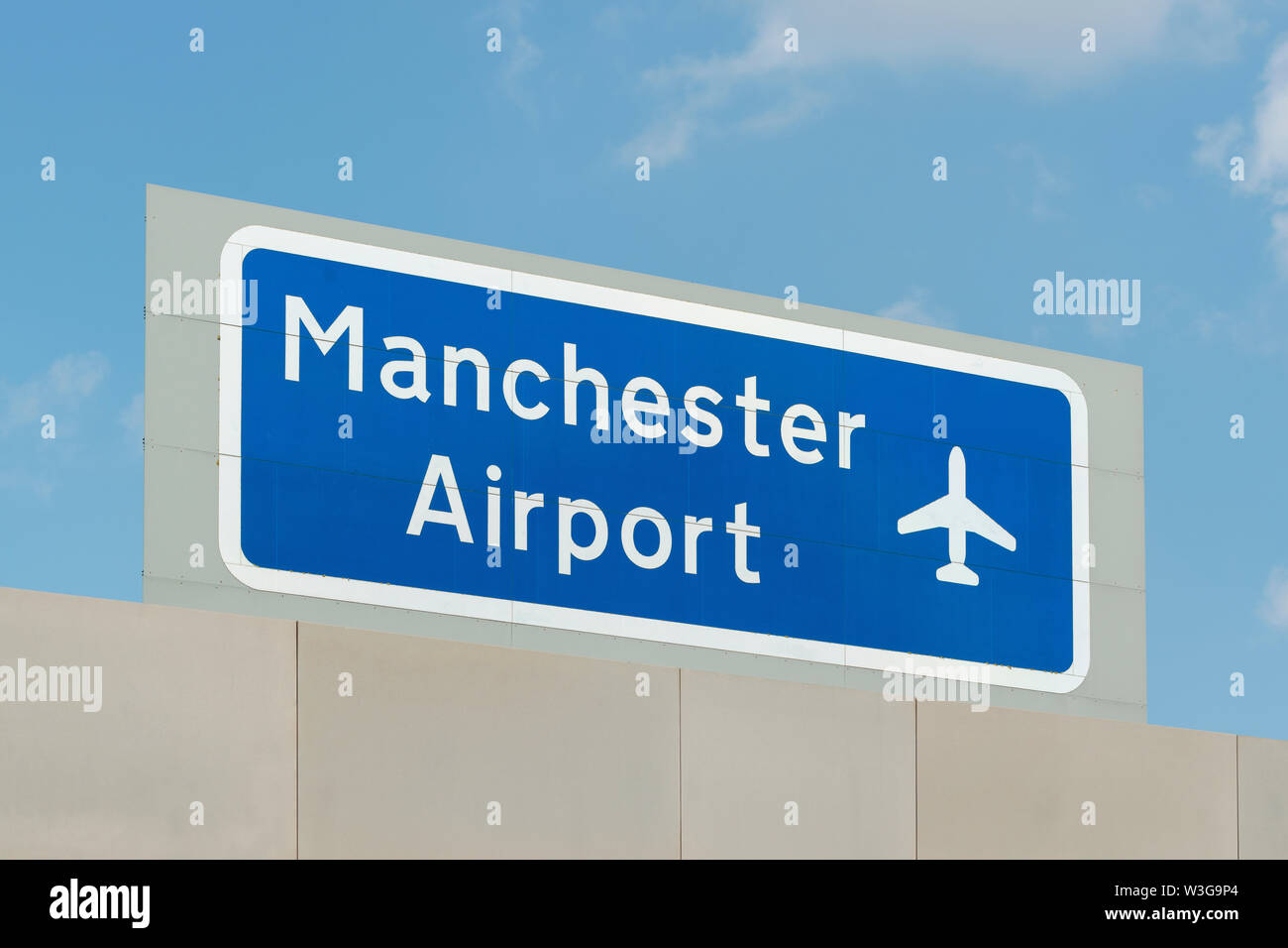 La signalisation pour l'aéroport de Manchester au-dessus d'une autoroute. Banque D'Images