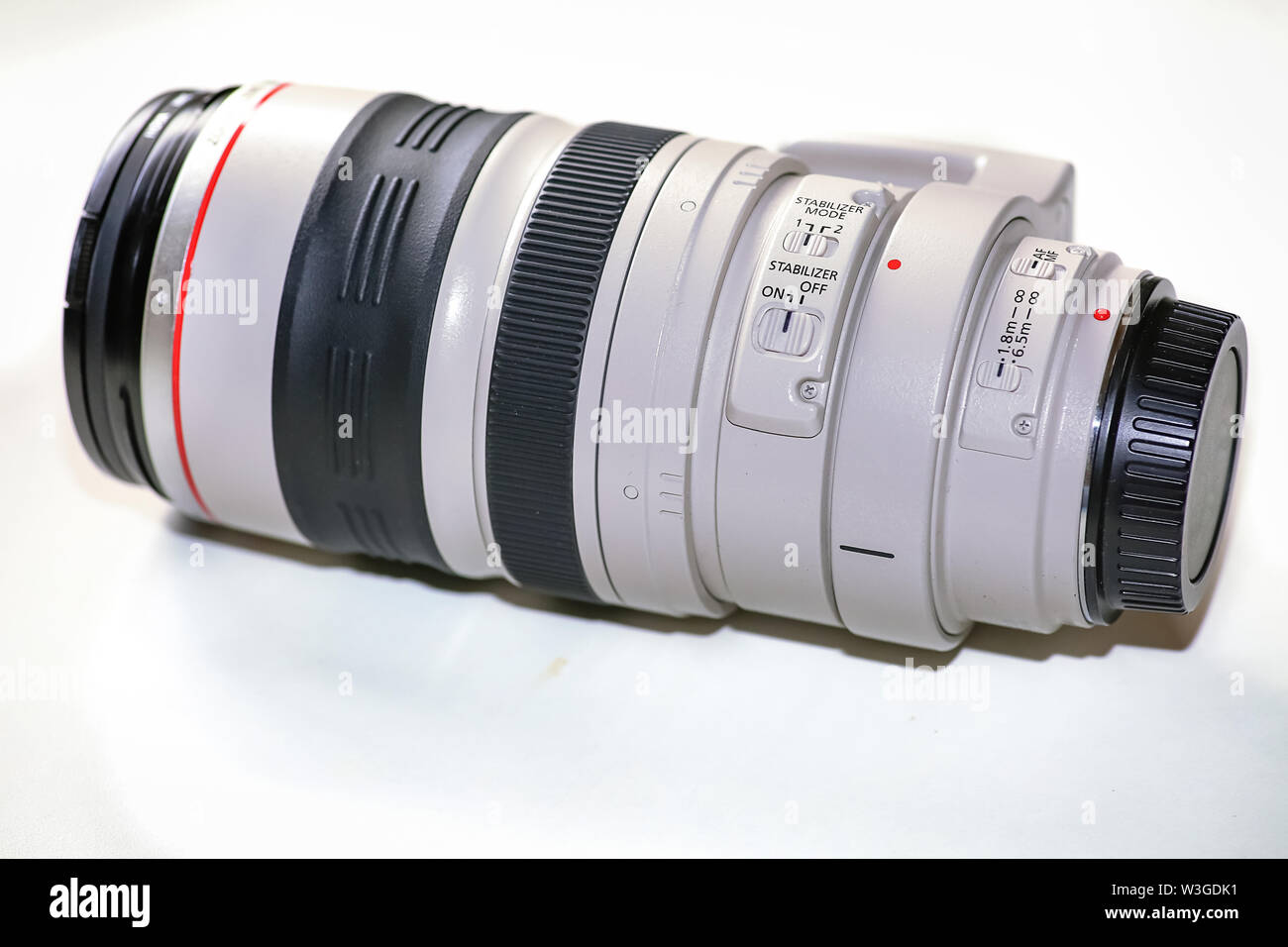 Téléobjectif Canon de 100-400 millimètres avec commutateurs de commande en vue rapprochée isolé sur fond blanc Banque D'Images