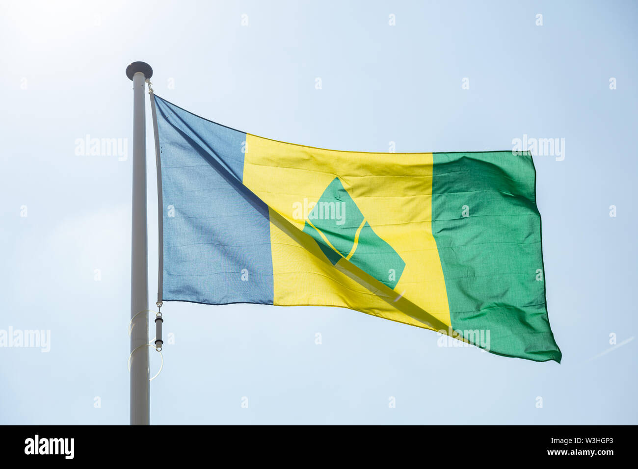 Saint Vincent et les Grenadines drapeau, symbole national en agitant contre ciel bleu clair, journée ensoleillée Banque D'Images