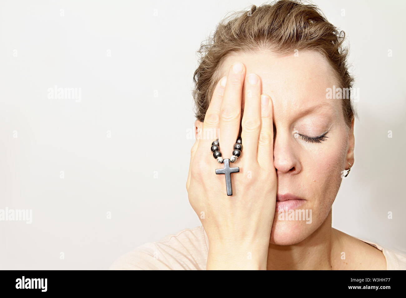 Femme en prière à Dieu avec sainte Croix dans ses mains avec un fond blanc stock image stock photo photo Banque D'Images