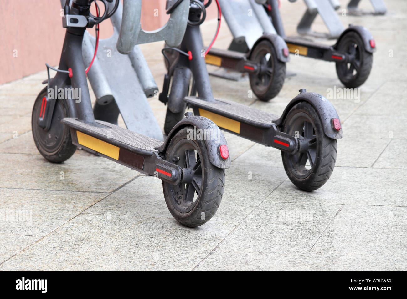 Des scooters électriques en stationnement sur un trottoir. L'E-scooter service de location, un temps pluvieux dans une ville Banque D'Images
