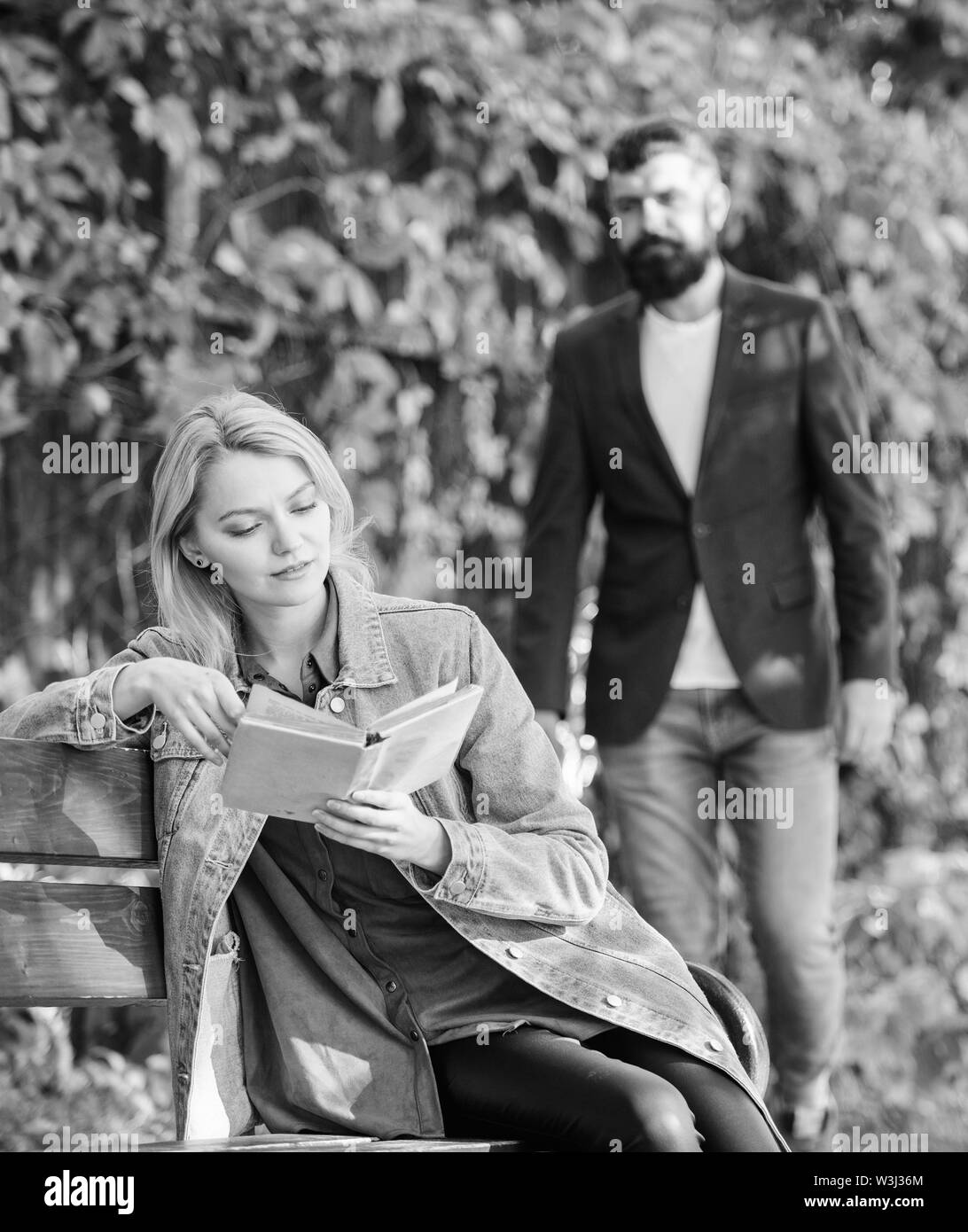 Rencontrez couple romantique en parc. femme lire intéressant livre. vous détendre sur banc de parc. La littérature. l'automne ou au printemps. La lecture est mon passe-temps. L'homme aime une fille. Jamais ennuyeux. D'abord répondre. Histoire d'amour. Banque D'Images