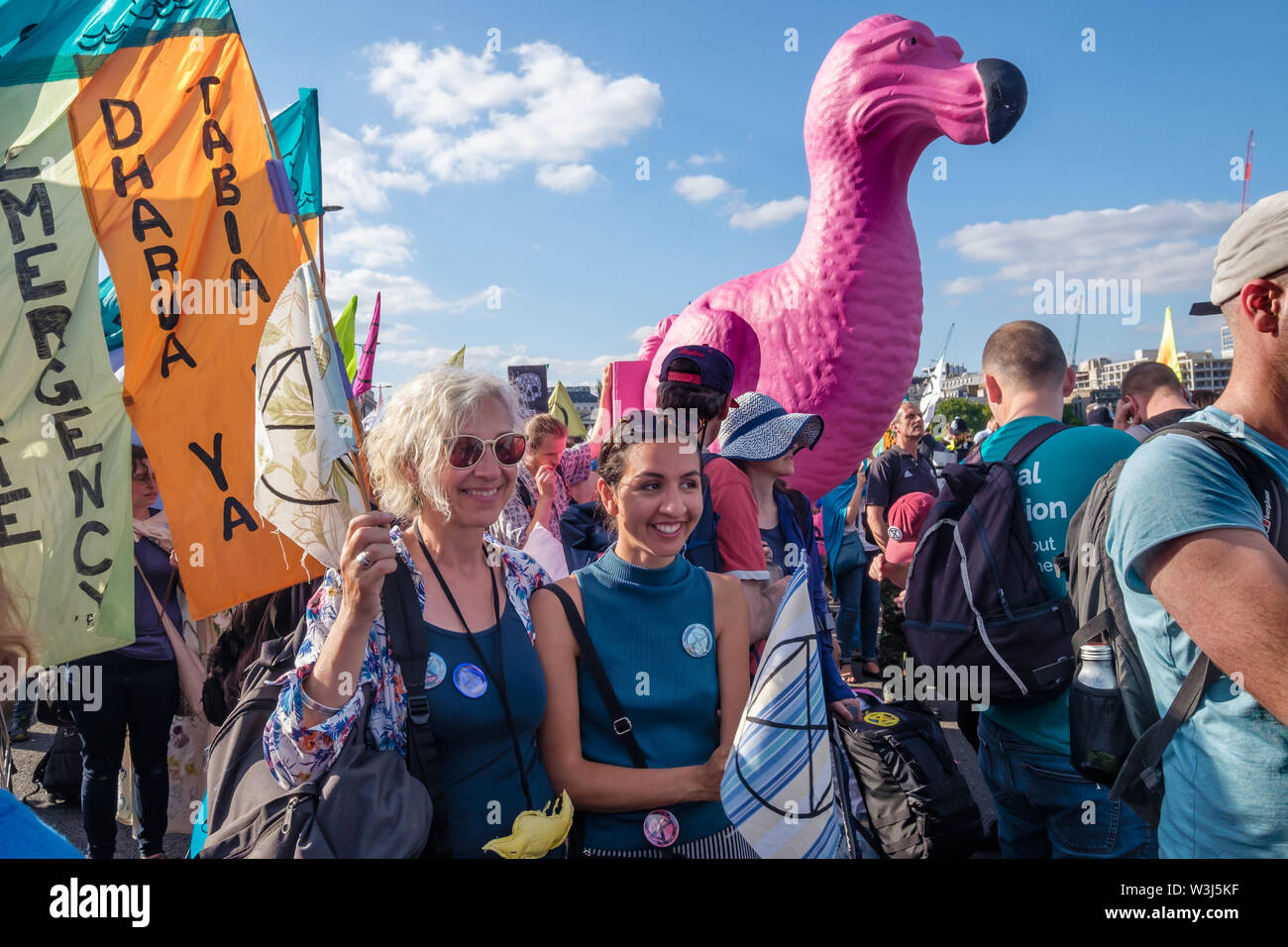 Londres, Royaume-Uni. 15 juillet 2019. Les gens, des bannières et un géant Dodo rose sur Waterloo Bridge sur l'extinction de la rébellion mars Royal Courts of Justice à leur site pour les trois jours à Waterloo millénaire vert. De même que les manifestants avec des bannières, il y avait une rose géante dodo, et à l'arrière de la procession le yacht Polly Higgins, nommé pour l'avocat qui se sont battus pendant des années pour une loi contre l'écocide et est décédé au mois d'avril. Crédit : Peter Marshall/Alamy Live News Banque D'Images