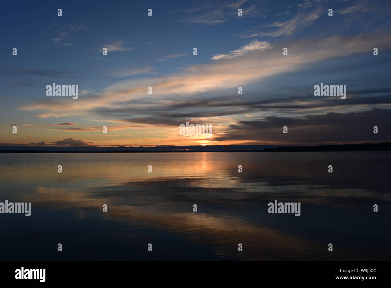 Sunbeam des nuages au coucher du soleil sur la surface de miroir de l'eau lac dans l'ombre et la lumière de la réflexion du ciel Banque D'Images