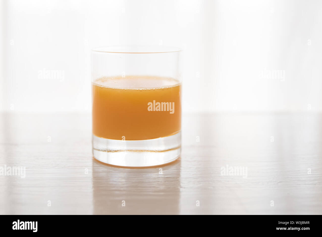 Les oranges avec un verre de jus d'orange sur un fond de table blanc Banque D'Images