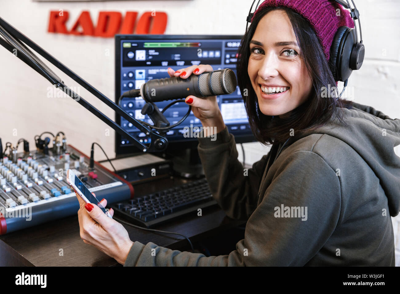 Belle jeune femme animatrice radio broadcasting en studio, à l'aide  d'ordinateur et les écouteurs Photo Stock - Alamy