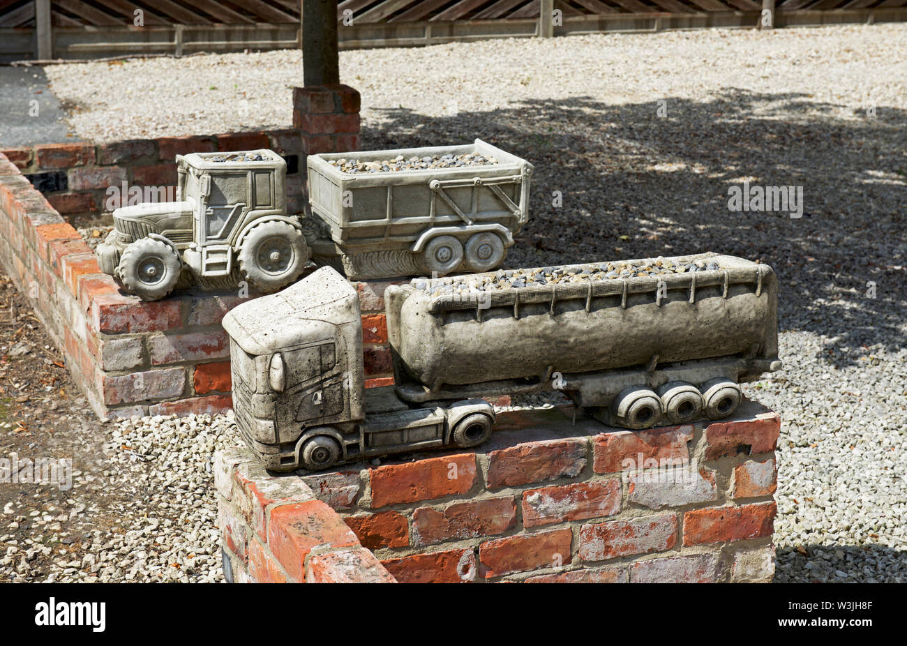 Ornements de jardin - tracteur et camion - au jardin, Drax village, North Yorkshire, England UK Banque D'Images