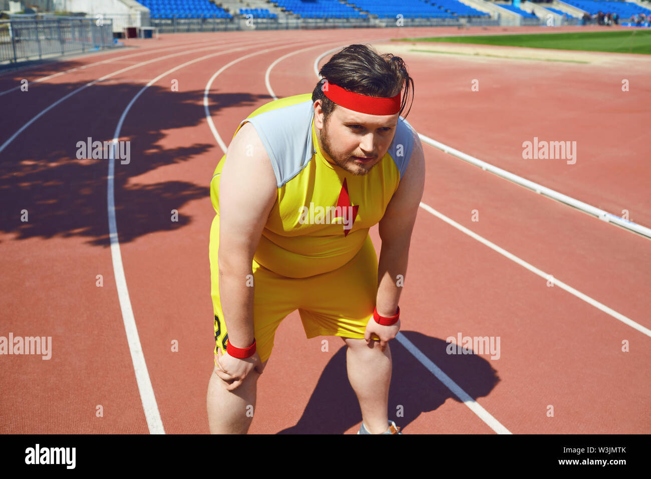 Homme triste gras dans le stade après la formation. Le concept de sport, la perte de poids, le régime alimentaire. Banque D'Images