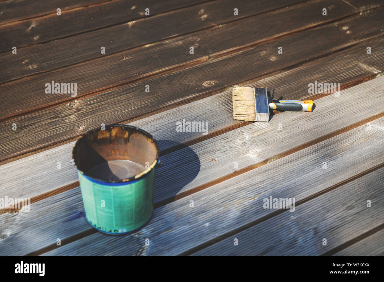 Restaurer les vieux bois terrasse en bois avec l'huile de protection Banque D'Images