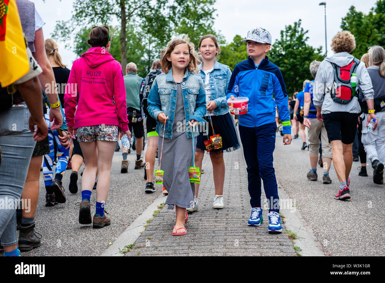 Les enfants distribuent des bonbons aux marcheurs lors de l'événement.Les quatre jours de marche sont un événement réalisation pendant quatre jours consécutifs, où chaque année des dizaines de milliers de marcheurs participent. Ces jours, les gens du monde entier viennent à Nimègue pour marcher dans et autour de la ville et ses beaux environs boisés. Des milliers de spectateurs sont en train d'encourager les marcheurs le long de la route tous les jours. Après quatre jours de marche, une glorieuse entrée le long de la Via Gladiola attend les marcheurs, suivie de la distribution de leurs quatre jours bien méritée Médaille. Banque D'Images