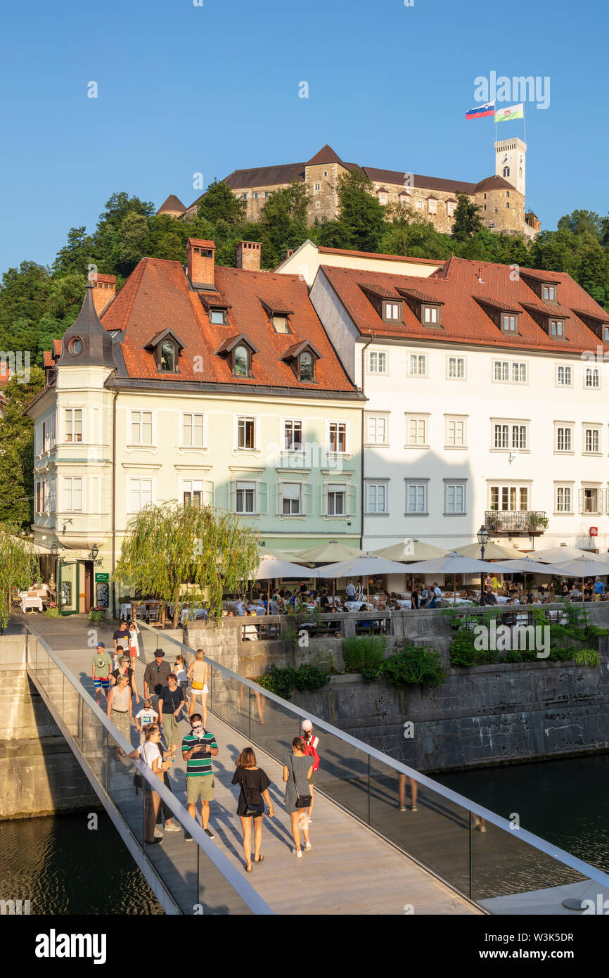 Les gens traversent le pont en verre Ribja Brv passerelle vers la vieille ville avec le château de Ljubljana Ljubljana Slovénie Europe UE ci-dessus Banque D'Images