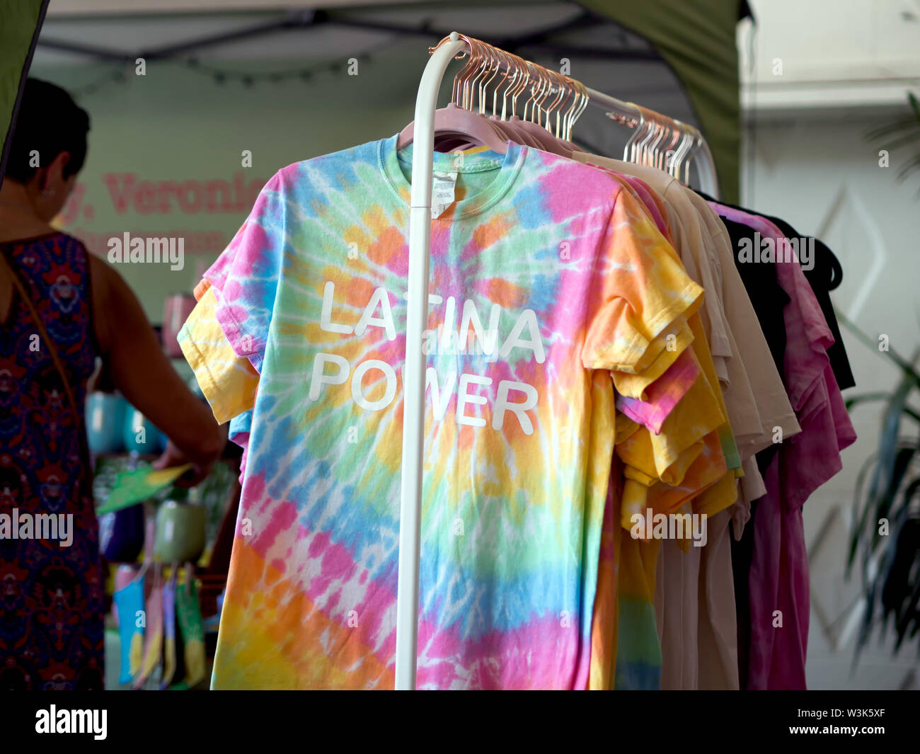 Tie-dyed t-shirts avec les mots 'Latina', alimentation à l'avant pour la vente à un 'Local' Loca pour événement au centre-ville de Corpus Christi, Texas USA. Banque D'Images