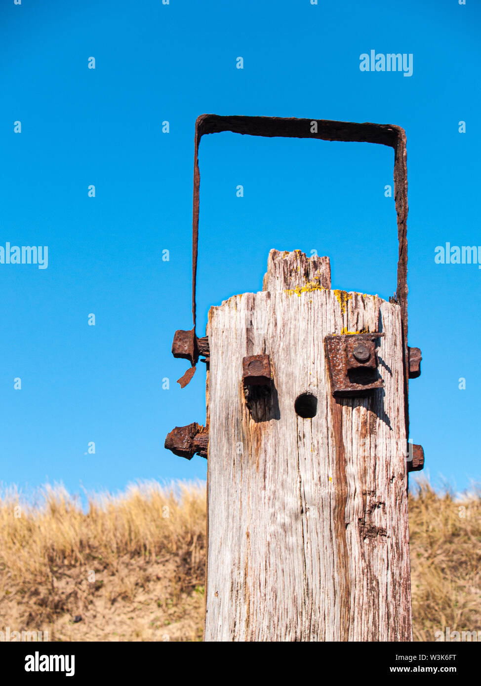 Un post en bois avec raccords rouillés qui ressemblent à une face du robot Banque D'Images
