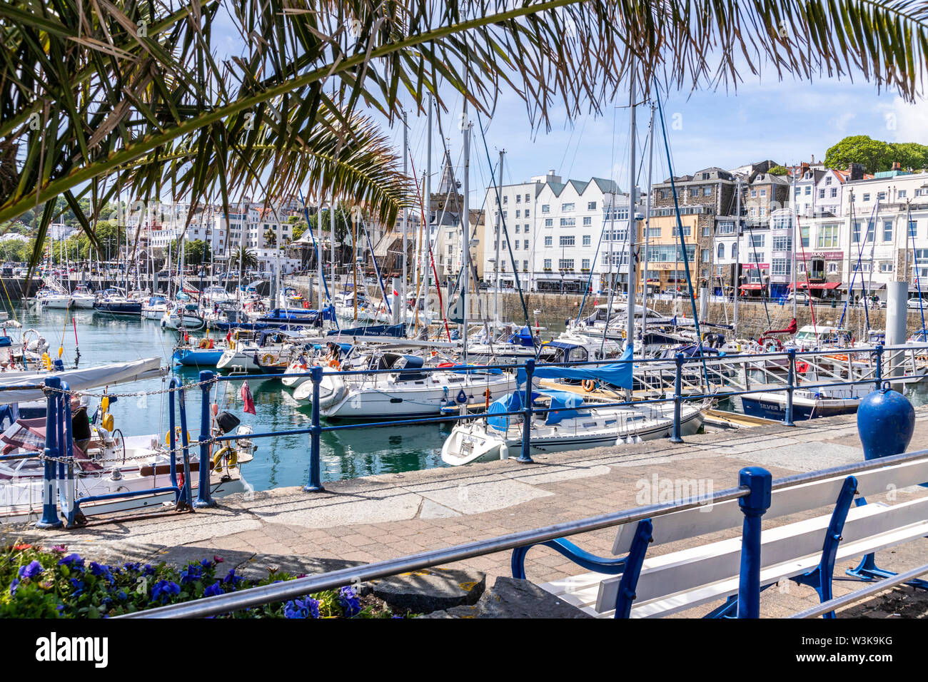 Dans le port des yachts amarrés en face de la ville, église St Peter Port, Guernsey, Channel Islands UK Banque D'Images