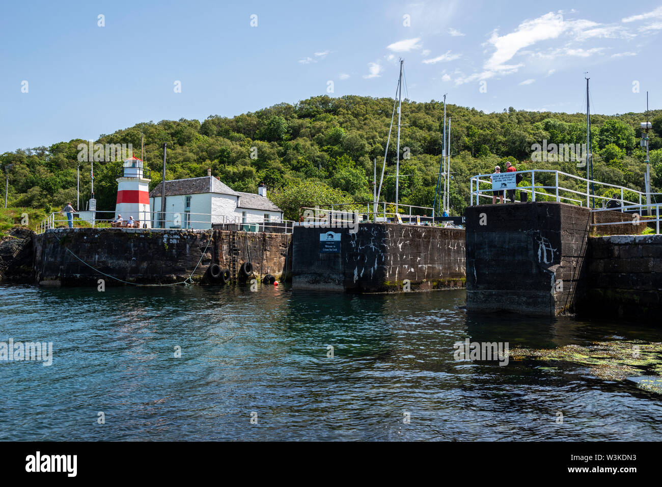 Vue extérieure de verrouillage (lock 15 mer) et phare de Crinan Canal Crinan sur village, Argyll and Bute, Ecosse, Royaume-Uni Banque D'Images